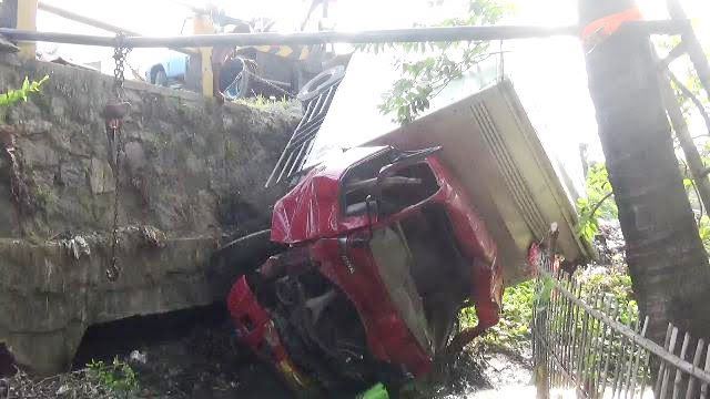 Putar Arah Diseruduk Truck, Mobil Box Terjun Ke Kali