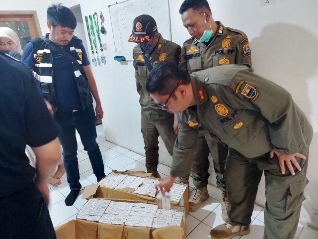 PENYITAAN: Satpol PP Bandung Barat bersama Tim Gabungan Bea Cukai Jabar saat melakukan penyitaan rokok ilegal di salah satu kantor barang dan jasa ekspedisi JNT Cargo di Desa Cipatik, Kecamatan Cihampelas. EKO SETIONO/PASUNDAN EKSPRES