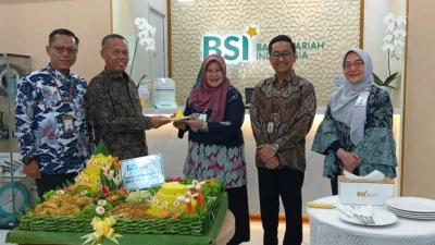 Pemotongan tumpeng usai pengguntingan pita menandai peresmian kantor baru BSI KCP Subang Otista.