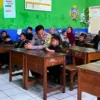 Seorang anak bernama Ilham Ramadhan (8) meminta polisi menemaninya saat pembagian rapor. (Foto: Istimewa)