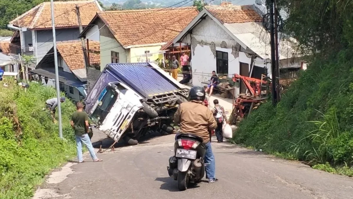 Truk pengangkut ratusan dus kopi terguling di jalur alternatif Dago Giri yang berada di Kampung Bunisari, Desa