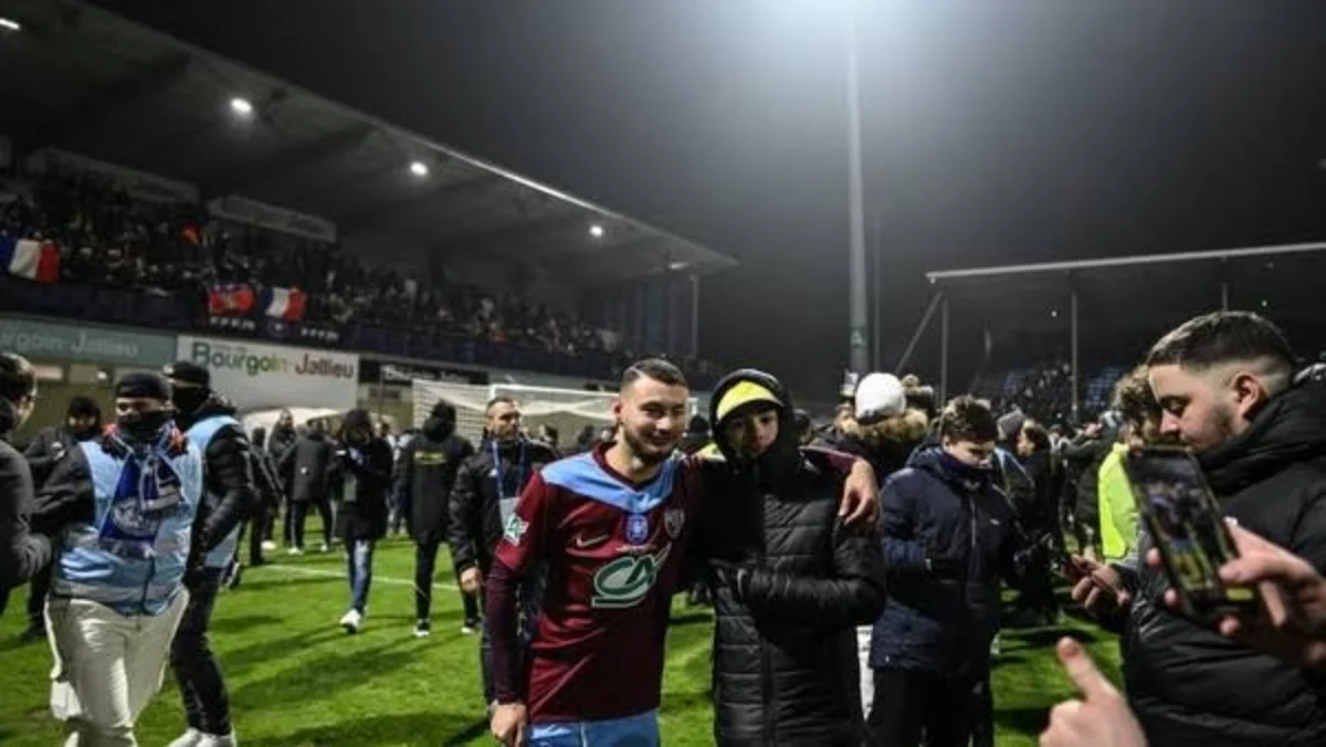 Fans Borgoun-Jallieu berhamburan ke lapangan usai timnya mengalahkan raksasa Ligue 1, Lyon. (Foto: JEFF PACHOU